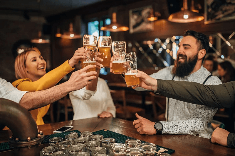 A group of guests enjoying drinks together at a busy bar