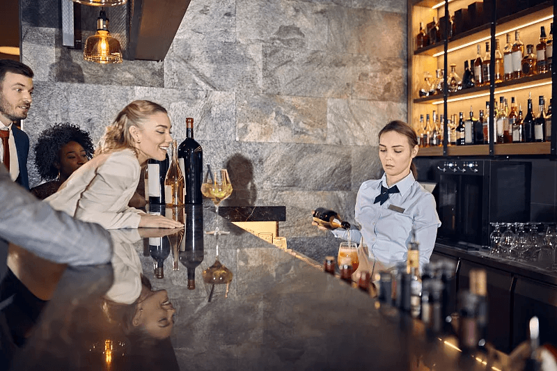 A guest completing payment at a bar counter