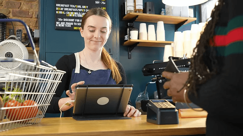 A restaurant team member using a point of sale system at the counter