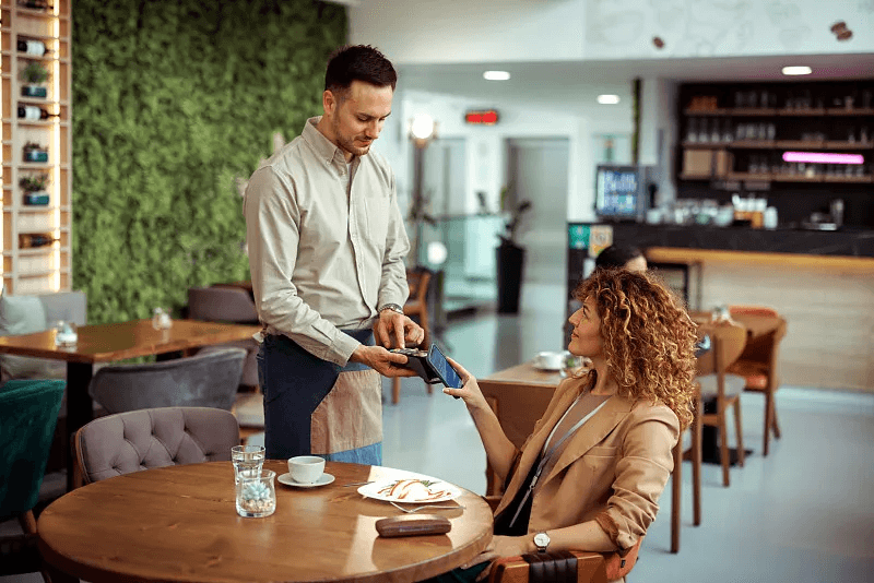 A guest completing a card payment at their restaurant table