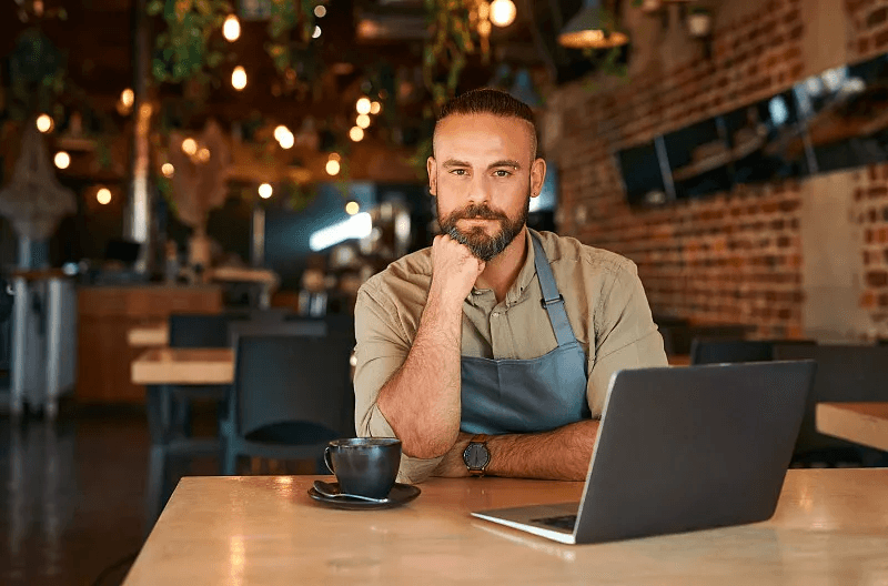 Restaurant manager reviewing customer insight data on a laptop