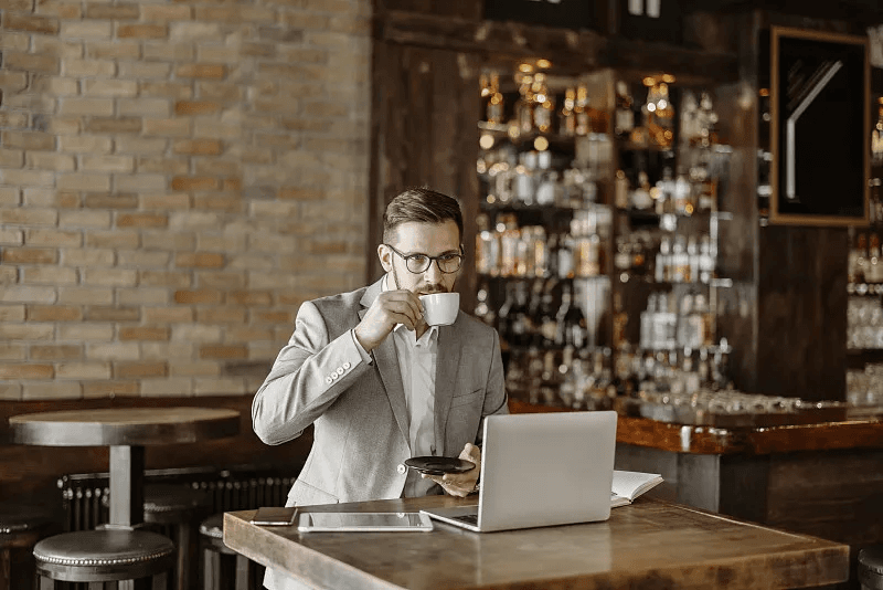 A cafe operator reviewing the business from a laptop